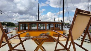 Ein Boot mit Holzboden, einem Tisch und zwei Holzstühlen.