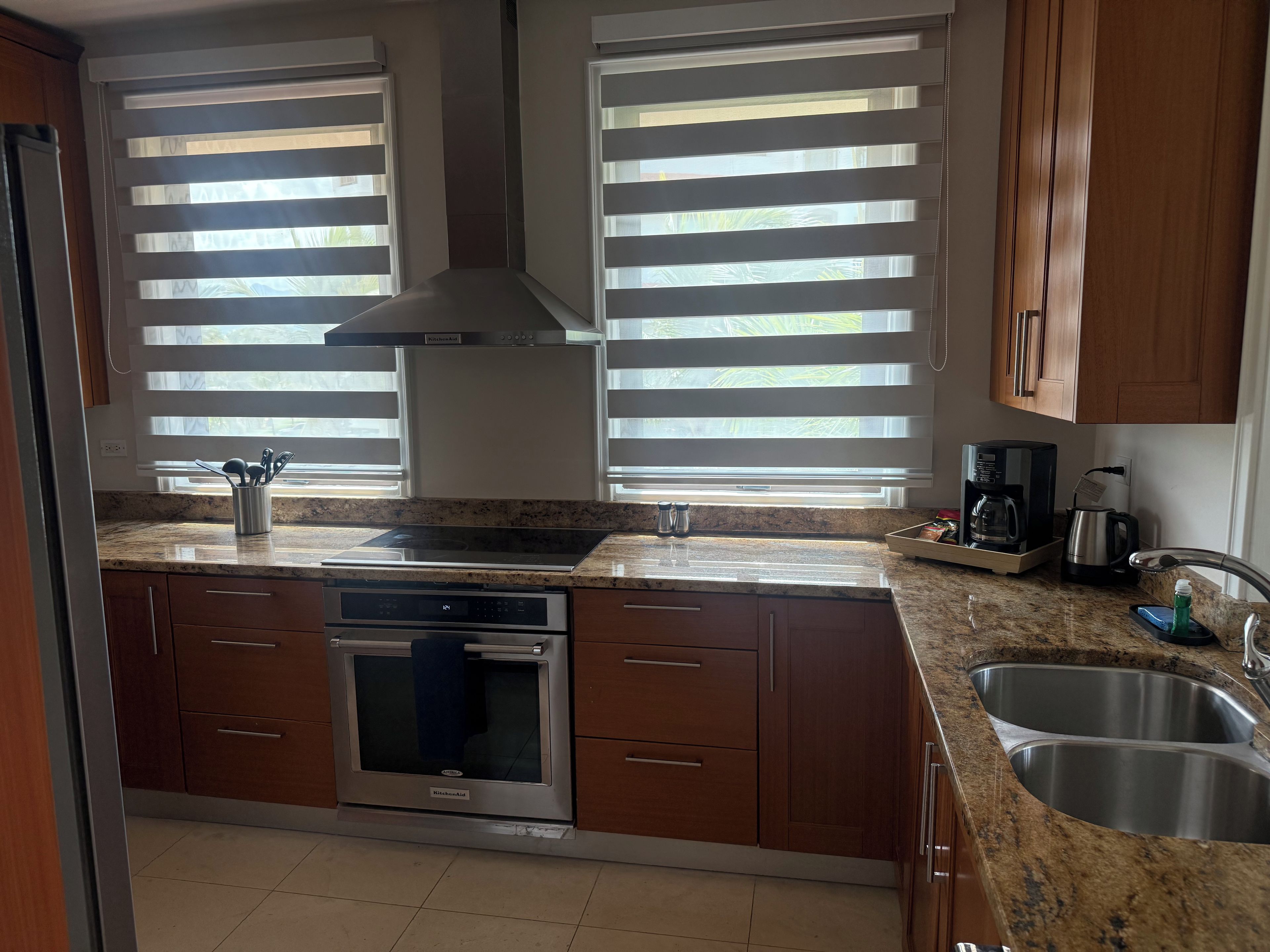 Una cocina con horno empotrado, microondas y cafetera.