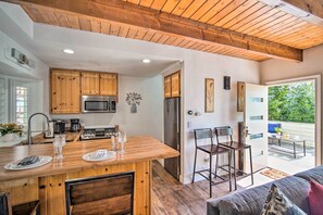 Una cocina moderna con armarios de madera, una isla central y un área de comedor con sillas.