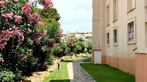 A pathway leading to a building with a beige facade and multiple windows. - Apartment in Clota Petita, L´Escala, 2 minutes from the beach! (L'Escala)