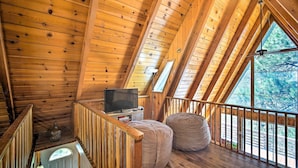 A wooden cabin with a loft bedroom, a television, and a large window. - Running Springs Cabin w/ Large Deck + View! (Running Springs)