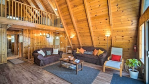 A cozy wooden interior with a loft bedroom, two sofas, a coffee table, and a chair. - Running Springs Cabin w/ Large Deck + View! (Running Springs)