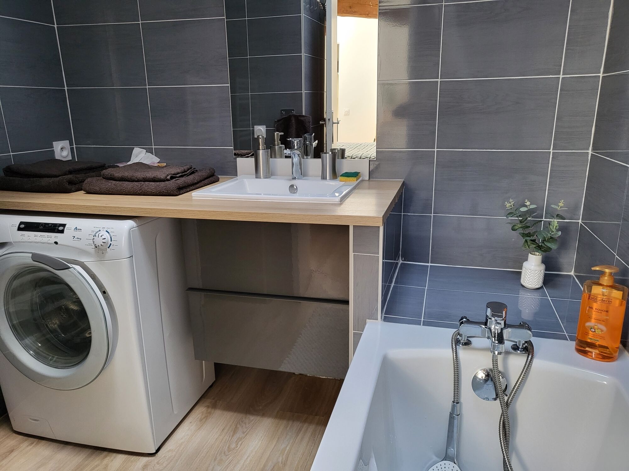 Un baño moderno con lavadora, lavamanos y bañera.