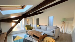 A modern living room with a wooden ceiling, a sofa, a coffee table, and a patterned rug. - La Dolce Vita Nîmoise 🐊 Terrace 100 m from the Arena (Nîmes)
