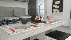 Una cocina moderna con estufa a gas, refrigerador y un adorno de pared decorativo.