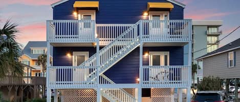 A two-story building with a balcony and a staircase.
