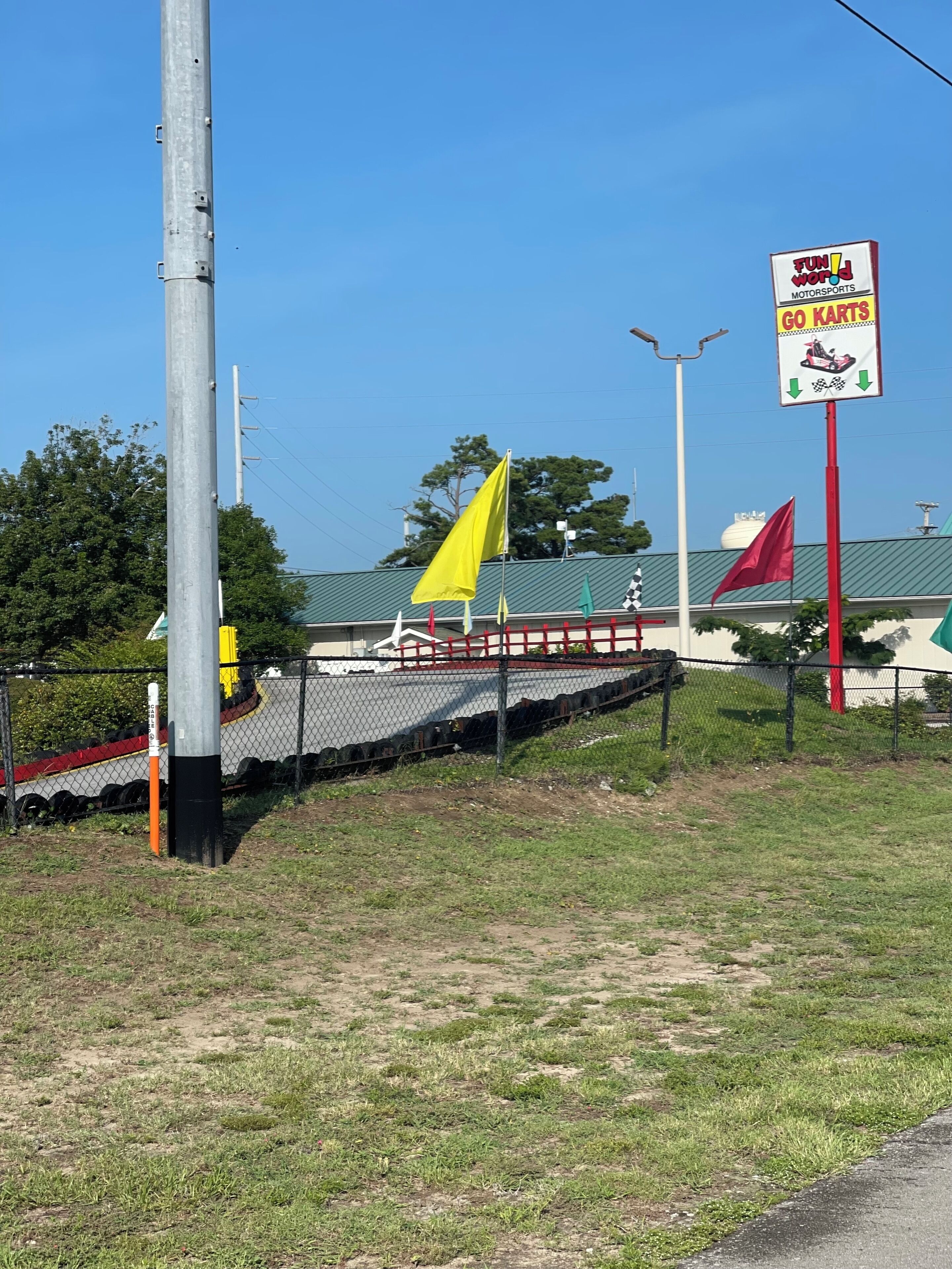 Een kartbaan met een bord voor Fun World Motorsports en een gele vlag.