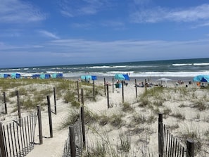 Ein Strand mit Zelten und einem Holzzaun.