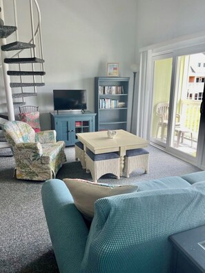 Relax in a cozy living space with a spiral staircase, flat-screen TV, and comfortable seating area.