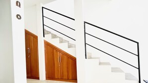 A modern interior with a staircase, wooden cabinets, and a white wall. - House at the Historical Arcos de Oaxaca (Oaxaca De Juarez)