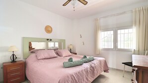 Ein Schlafzimmer mit einem Bett, Nachttischen, einem Schreibtisch und einem Stuhl.