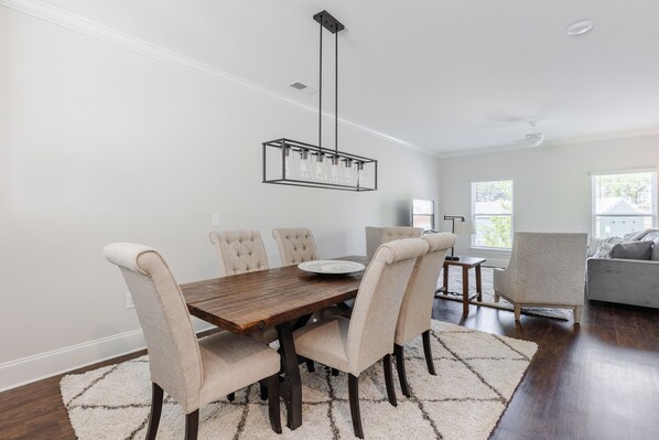 A dining area with a wooden table, four upholstered chairs, a chandelier, and a rug. - CLOSE TO DOWNTOWN GREENVILLE (Greenville)