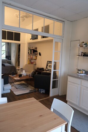 A compact hotel room with a dining area, a kitchenette, and a small living space. - 1 Bedroom Apartment in Brooklyn (Brooklyn)
