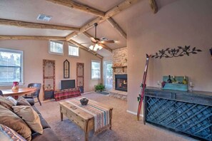 Una sala de estar acogedora con chimenea, vigas de madera, pared de piedra y un botellero.