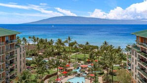 A resort with a pool, palm trees, and a view of the ocean. - Maui Resort Rentals: Honua Kai Konea 929 – 9th Floor 3BR W/ Stunning Ocean Views from All 3 Bedrooms! (Lahaina)