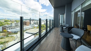 A balcony with a city view, modern chairs, and a glass railing. - KOKO HOTEL Premier Kumamoto (Kumamoto)
