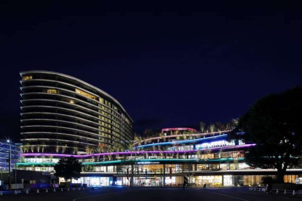 A modern hotel with a curved facade, multiple floors, and illuminated signage.