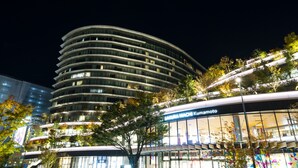 A modern building with multiple floors, large windows, and a sign for 'SAKURA MACHI Kumamoto'. - KOKO HOTEL Premier Kumamoto (Kumamoto)