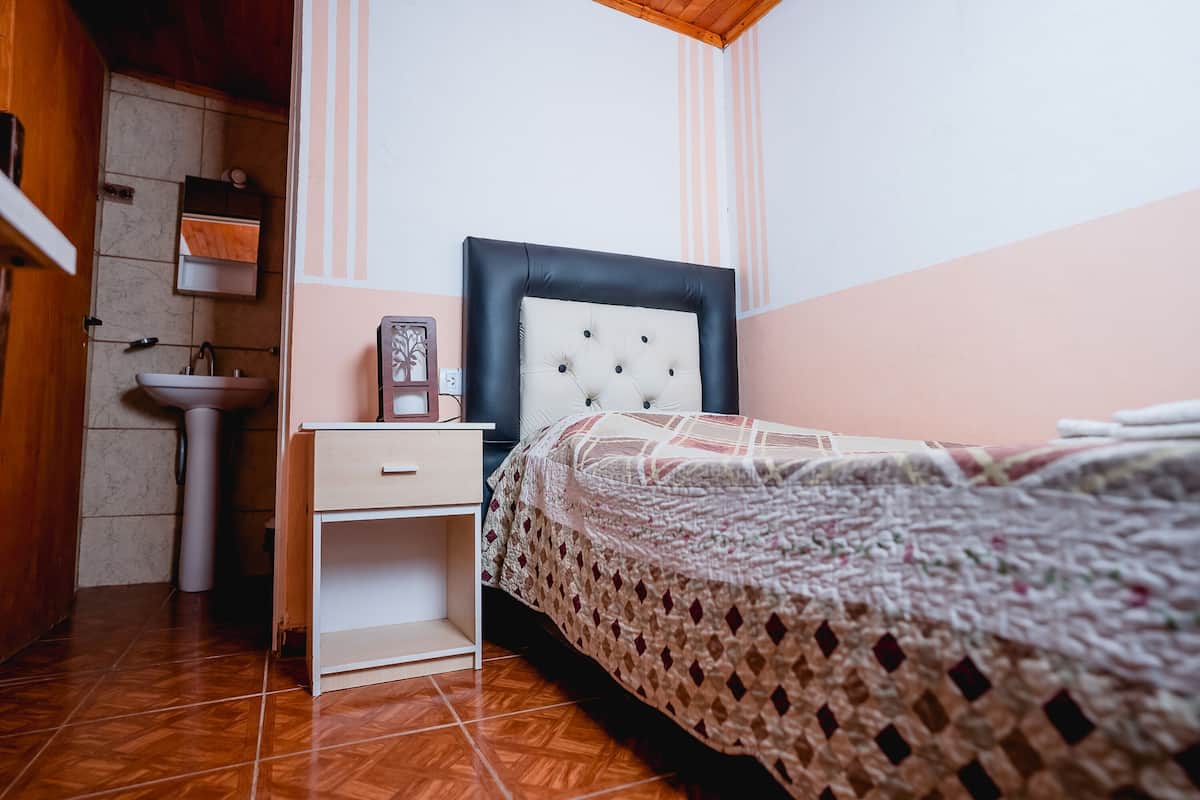 Une chambre à coucher avec un lit, une table de chevet et une commode.