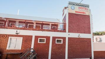 A hotel with a sign indicating it is a "HOTEL Raquel Lito" and has a parking area.