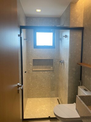 Chuveiro, toalhas de banho, sabonete, papel higiênico