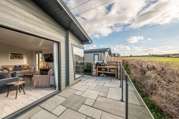 A modern house with a patio area featuring a sofa, coffee table, and outdoor seating.