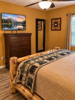 A bedroom with a bed, a dresser, a mirror, and a painting of a mountain landscape. - WOW 🤩 3BR Cabin just 2 miles to Dollywood + Arcades! (Sevierville)