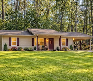 A two-story house with a covered porch and a well-maintained lawn.
