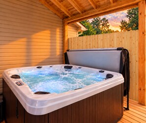 A hot tub in a wooden deck area with a view of trees and a sunset. - WOW 🤩 3BR Cabin just 2 miles to Dollywood + Arcades! (Sevierville)