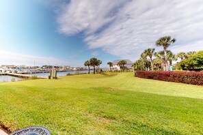 Enjoy serene surroundings with manicured lawns, palm trees, and a tranquil marina view.