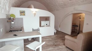 A compact living space with a kitchenette, a dining area, and a seating area. - La Maison Petite, Le Piccole Case Bianche (Ostuni)