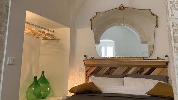 A bedroom with a bed, a mirror, and a hanging light fixture. - biancostuni66, Le Piccole Case Bianche (Ostuni)