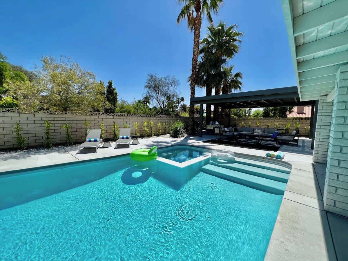 Une piscine avec des chaises longues et un espace de détente abrité.