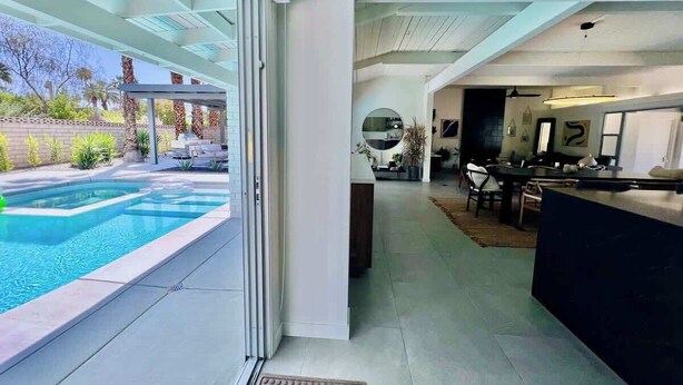 Um interior moderno com piscina, cozinha e área de refeições.
