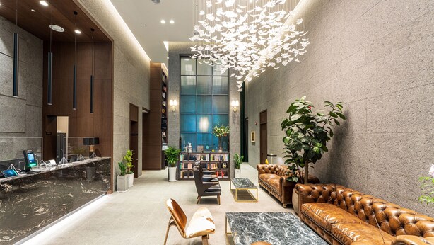 A modern lobby with a reception desk, seating area, and a large bookshelf. - Hotel Soulhada (Incheon)
