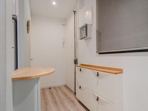 A narrow hallway with a wooden bench, a wardrobe with brown handles, and a wall-mounted air conditioning unit. - Sants Montjuic Olympic View (Barcelona)