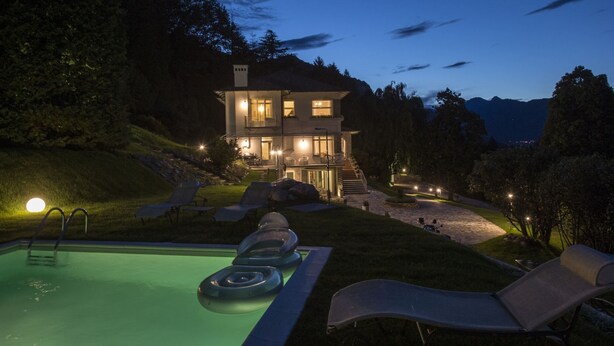 A two-story house with a swimming pool, lounge chairs, and a staircase leading to the entrance. - VILLA NINFEA DEL LAGO (Baveno)