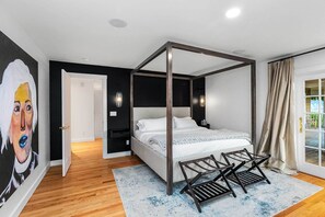 A bedroom with a four-poster bed, a wooden floor, a large window with curtains, and a painting on the wall. - 'The Hammersley' Luxury Waterfront Estate! (Shelton)