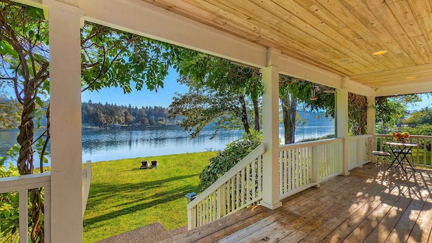 A covered deck with a view of a lake and grassy area. - 'The Hammersley' Luxury Waterfront Estate! (Shelton)