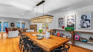 A spacious dining area with a wooden table, chairs, and a hanging light fixture. - 'The Hammersley' Luxury Waterfront Estate! (Shelton)