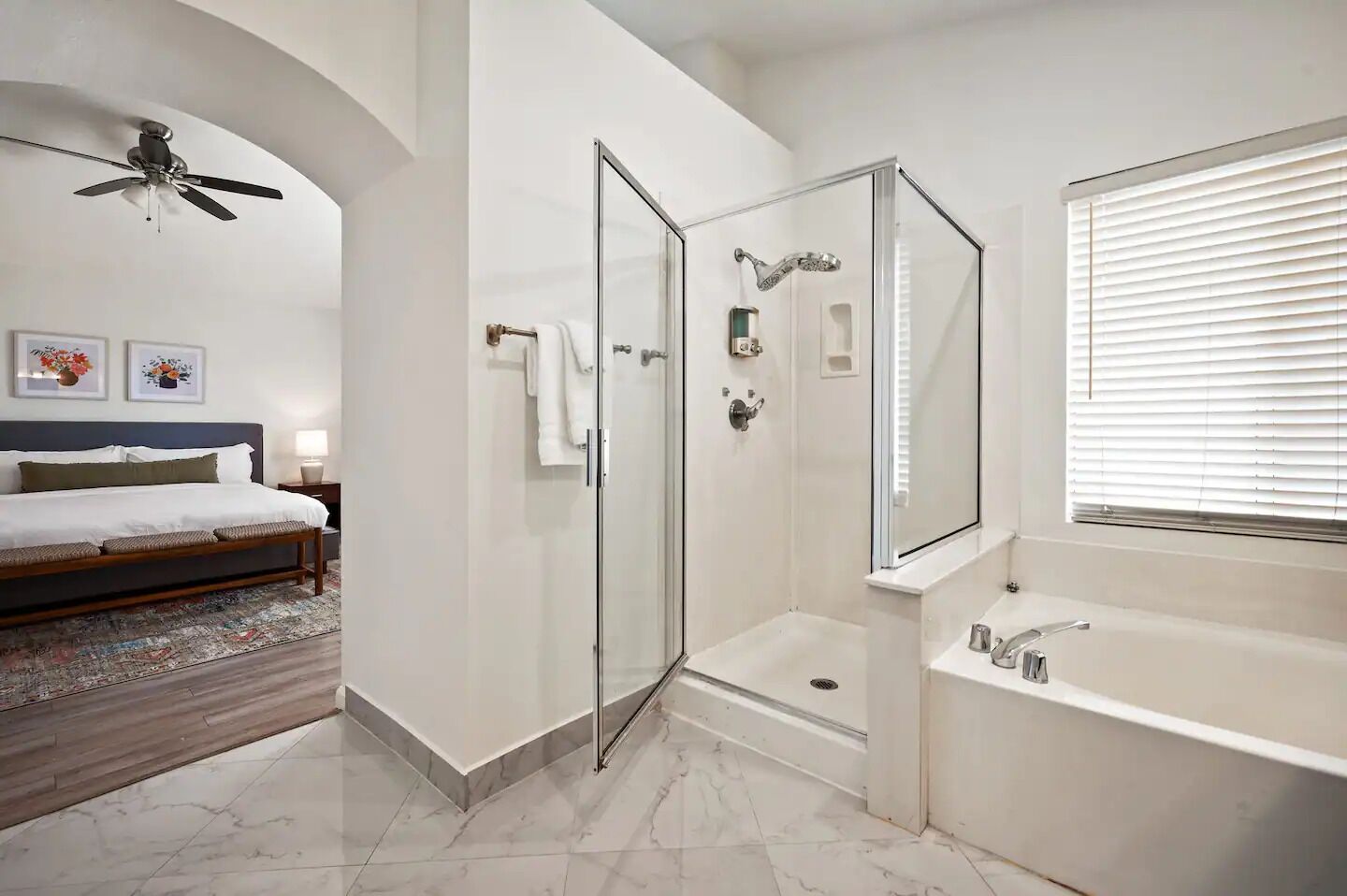 Une salle de bain moderne dotée d’une douche à parois de verre, d’une grande baignoire et d’un ventilateur de plafond.