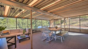 A covered outdoor seating area with a wooden ceiling, large windows, and a view of the outdoors. - Jackson Escape w/ Hot Tub & Mtn Views! (Jackson)