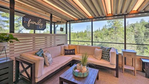 A modern outdoor seating area with a wooden ceiling, a 'family' sign, and a 'home' sign on the sofa. - Jackson Escape w/ Hot Tub & Mtn Views! (Jackson)