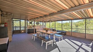 A spacious room with a large table, benches, and a view of the outdoors. - Jackson Escape w/ Hot Tub & Mtn Views! (Jackson)