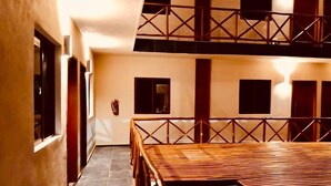A spacious interior with a high ceiling, a wooden table, and a balcony with a railing. - Hotel Manglar Suites (Mahahual)