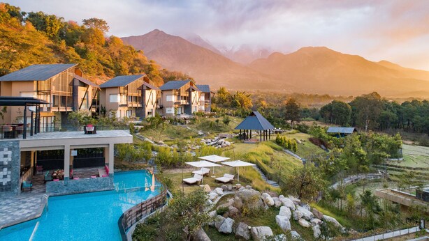 A resort with multiple buildings, a swimming pool, and a mountainous backdrop. - Norbu The Montanna, Dharamshala - IHCL SeleQtions (Dharamshala)