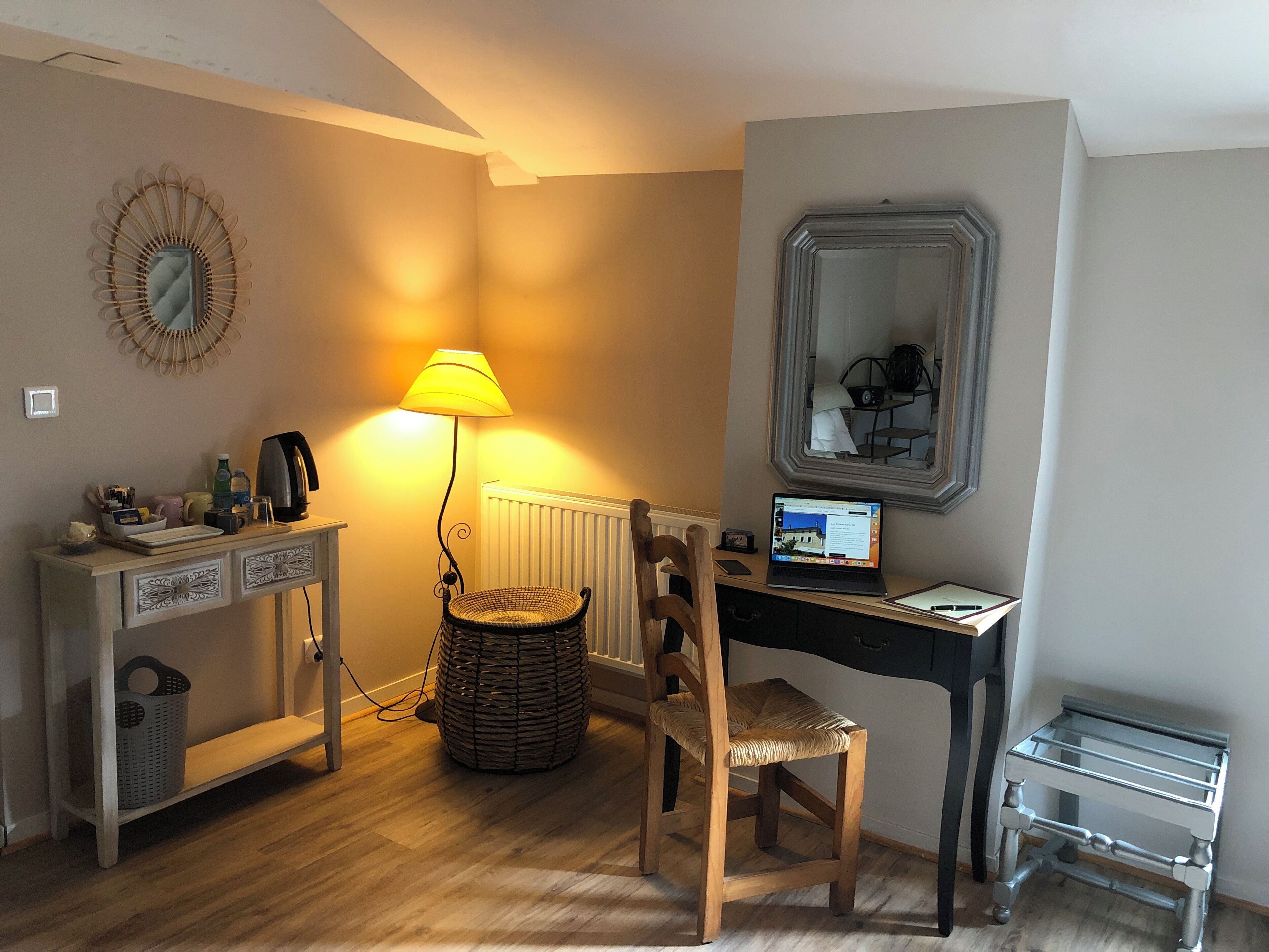 Une petite pièce comprenant un bureau, une chaise, une lampe et un ordinateur portable.