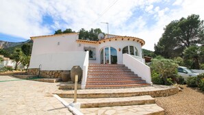 Un bâtiment blanc doté d’un toit incurvé et d’un escalier menant à l’entrée.