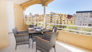 Ein Balkon mit Korbmöbeln und Blick auf die umliegenden Gebäude.