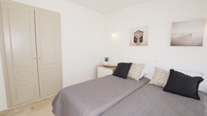 A bedroom with a double bed, two bedside tables, a nightstand, a wardrobe, and a wall-mounted picture. - A85 EDIFICIO OCEANIC 304 (Calpe)